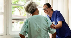 Smiling nurse helping older women to window